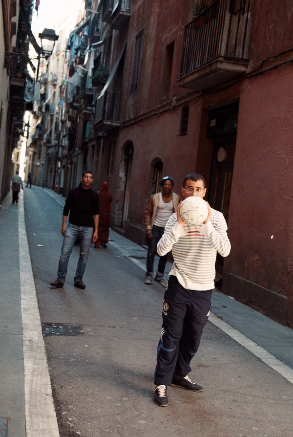 Момчета играят футбол на улица в Барселона.
