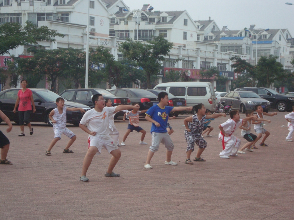 Китай, Пънлай, Деца тренират кунг фу на улицата
