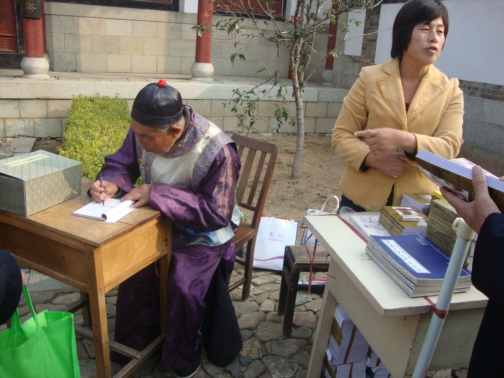 Китай, Писател дава автограф
