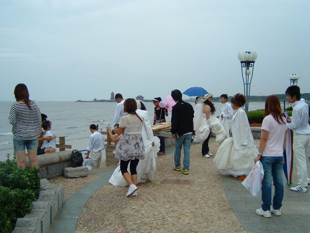 Китай, Пънлай, Булки чакат ред за снимки на плажа
