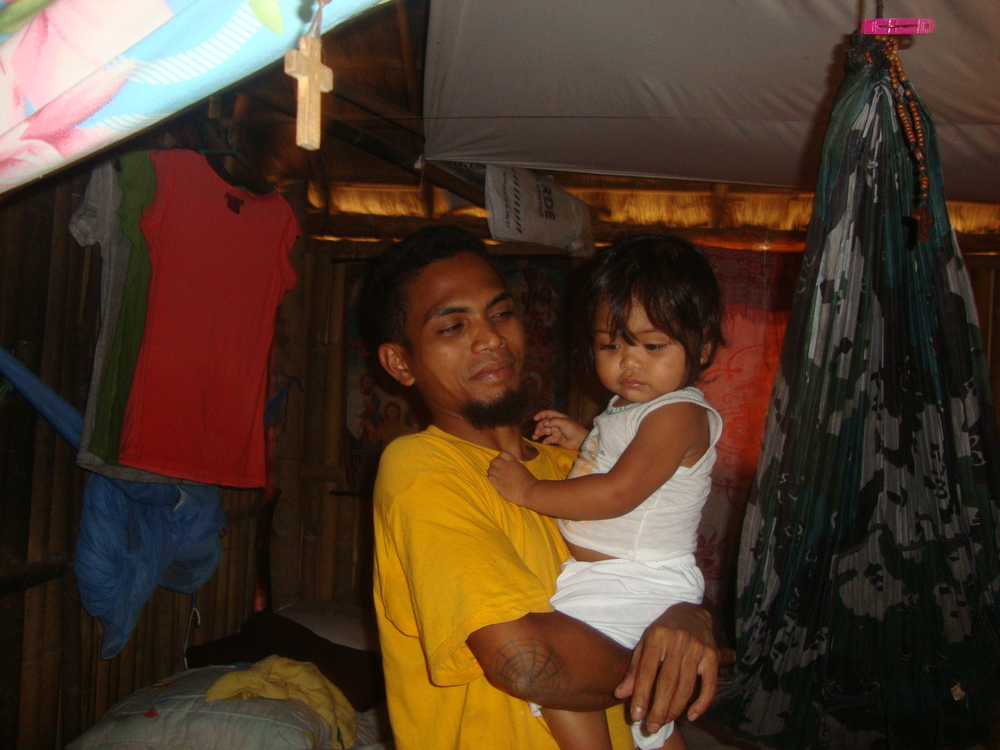 Филипини, бащина гордост. Вдясно е закачена бебешката люлка. Дървено кръстче пази семейството.
