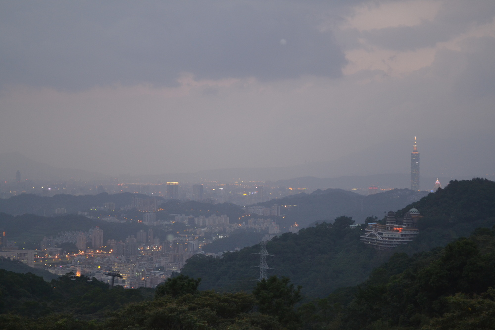 Тайван, Тайпе, Маоконг, гледката към Тайпе 101 на свечеряване. Запалват първите светлини.

