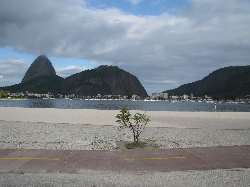 Бразилия, Рио де Жанейро, Там - зад крайбрежната закачливо наднича "Захарната глава"
